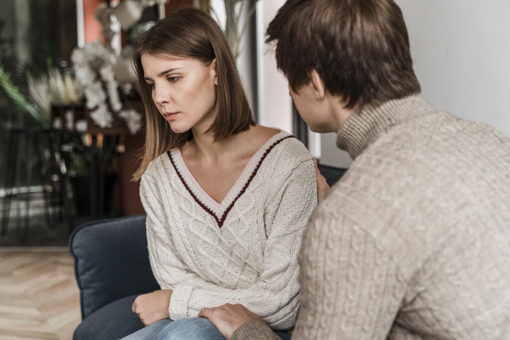 An informative blog image highlighting the 'Five Key Signs of Trauma in Your Partner.' The image visually represents the themes of understanding and supporting a traumatized partner in a romantic relationship, focusing on guilt, anxiety, anger, low self-esteem, and trust issues as well as the importance of seeking professional help for trauma in relationships.